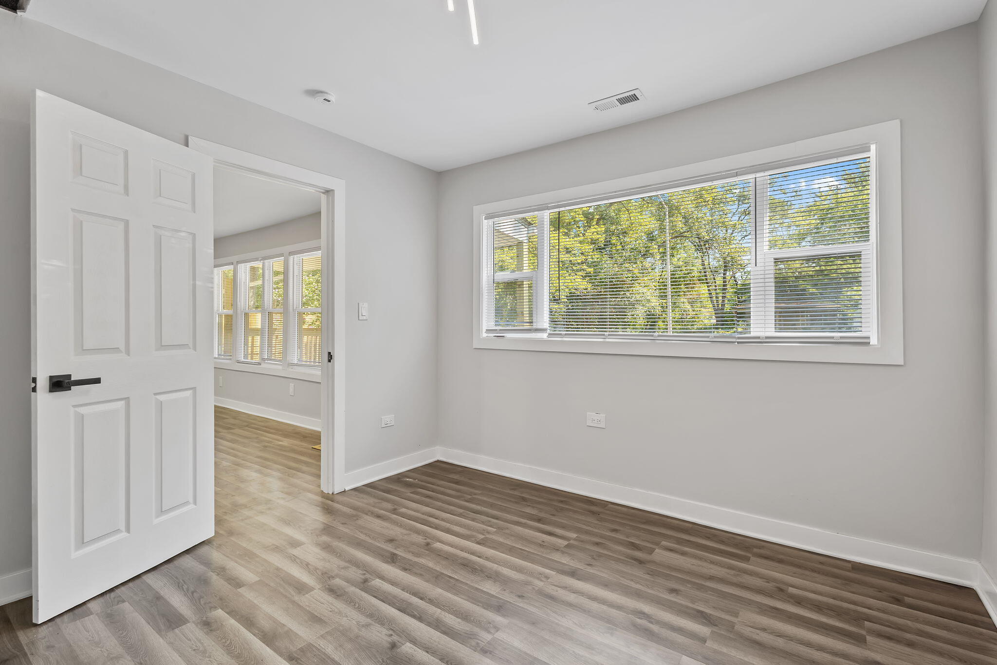2368 Wheeler Street Gary, IN 46406 - Photo 8 of 16 a view of an empty room with wooden floor and a window