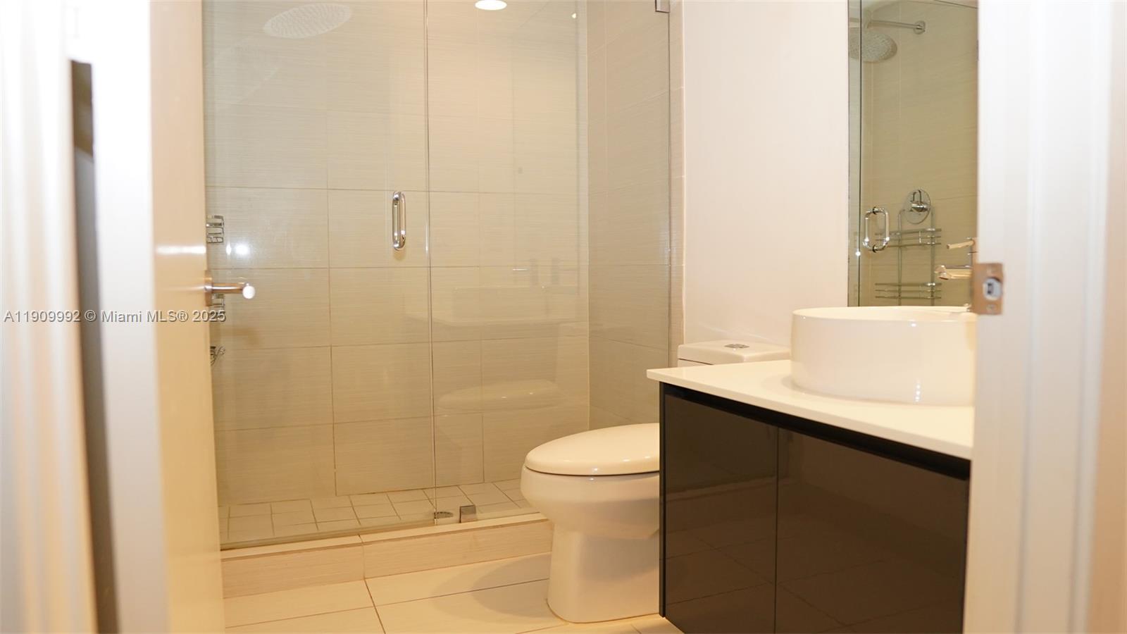 31 Southeast 6th Street, Unit 1108 Miami, FL 33131 - Photo 11 of 22 a bathroom with a sink a toilet and shower