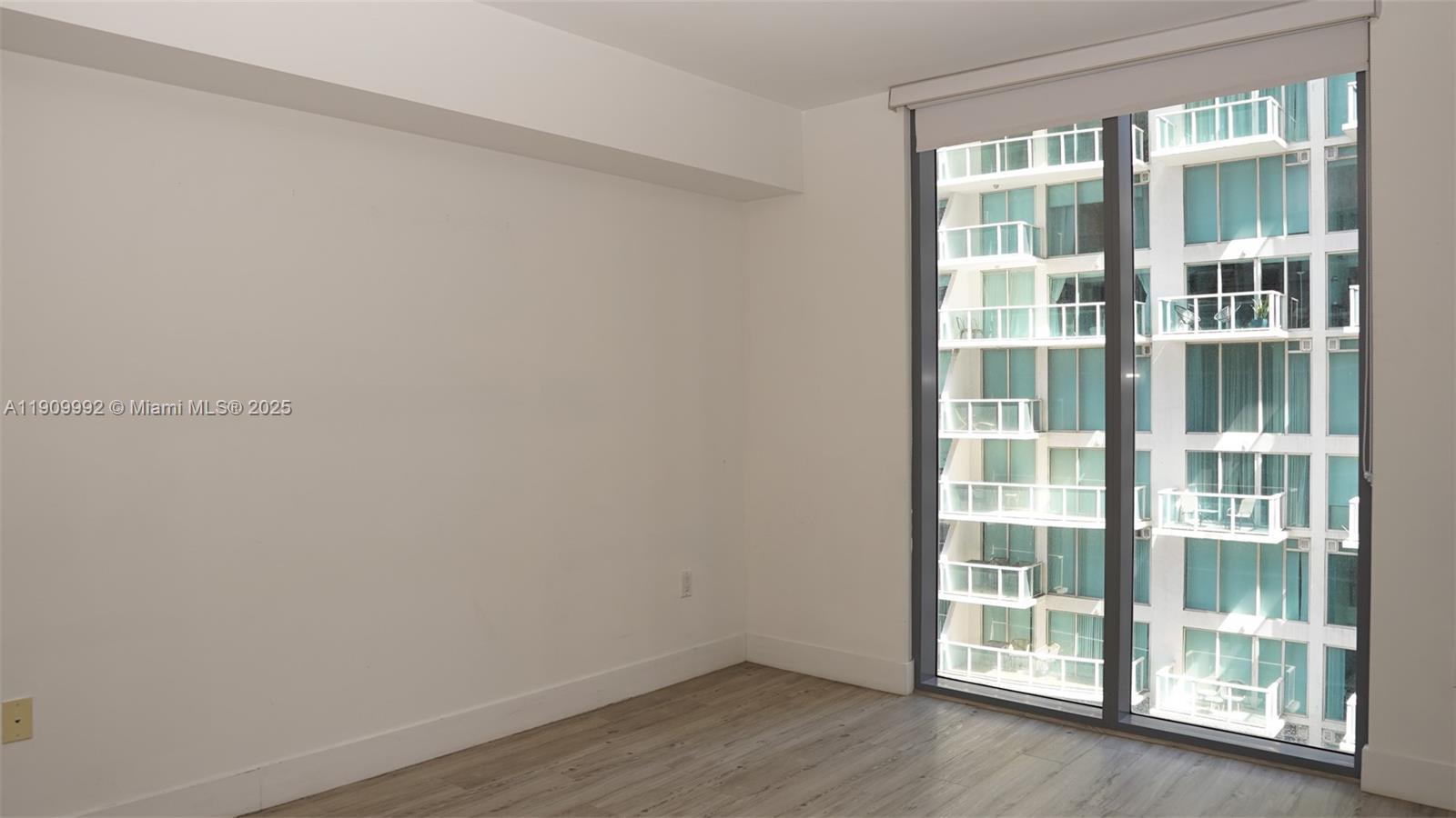 31 Southeast 6th Street, Unit 1108 Miami, FL 33131 - Photo 15 of 22 an empty room with wooden floor and windows
