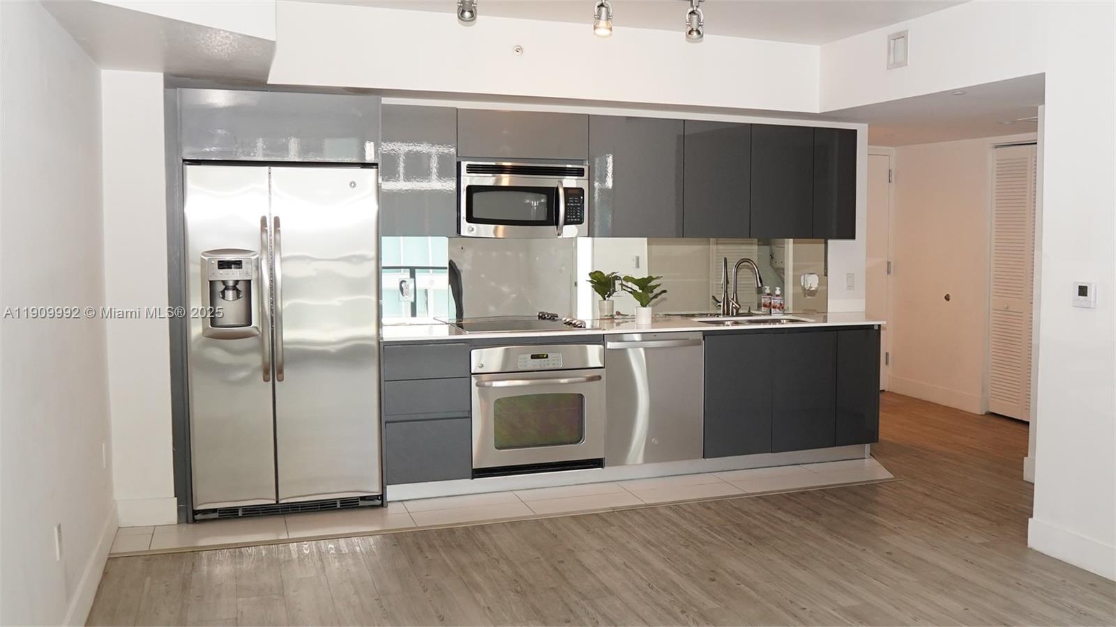 31 Southeast 6th Street, Unit 1108 Miami, FL 33131 - Photo 3 of 22 a kitchen with stainless steel appliances a refrigerator and a stove