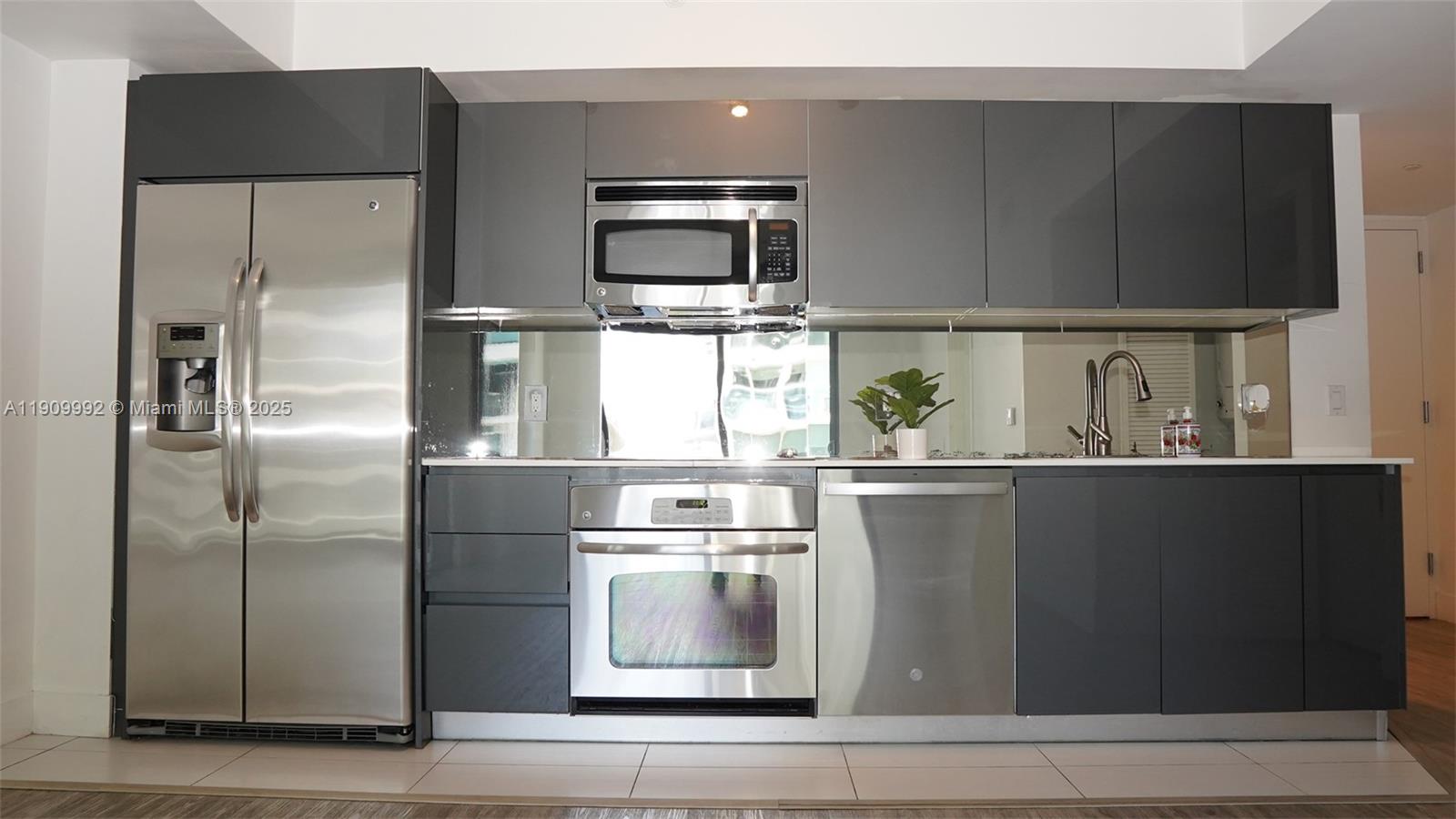31 Southeast 6th Street, Unit 1108 Miami, FL 33131 - Photo 5 of 22 a view of a refrigerator in kitchen and wooden floor
