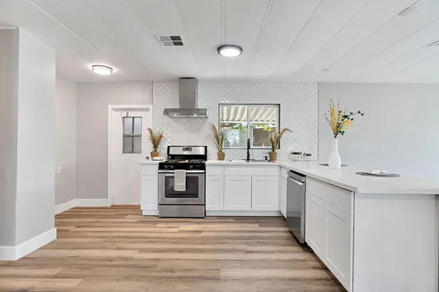 a kitchen with stainless steel appliances a white stove top oven and cabinets
