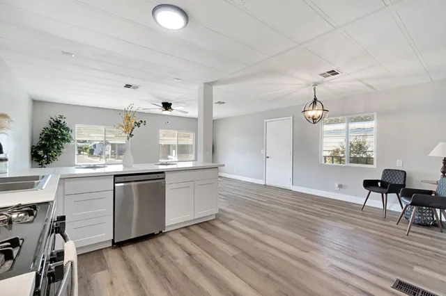 a kitchen with granite countertop a stove a sink and a refrigerator