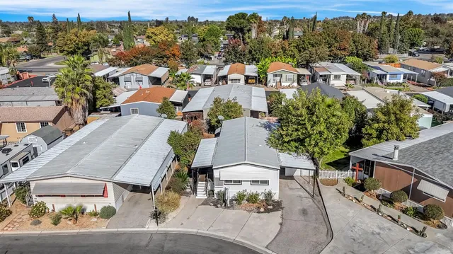 an aerial view of a house with a yard and seating space