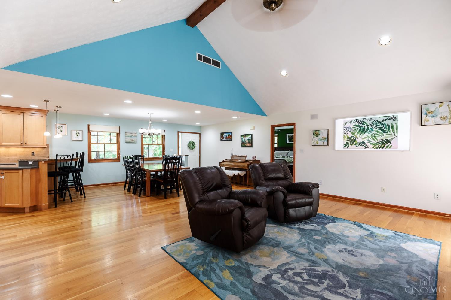 623 Ibold Road Loveland, OH 45140 - Photo 9 of 35 The dramatic great room features soaring vaulted ceilings with exposed beam accents, a cozy wood-burning fireplace, and expansive windows and walkout access to the deck via French doors that fill the space with natural light.