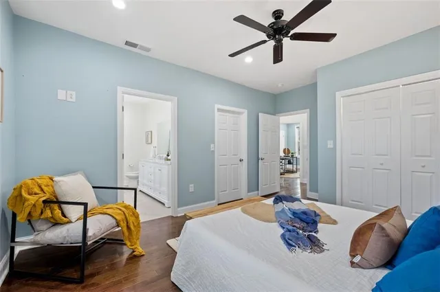 a spacious bathroom with a double vanity sink toilet mirror and shower
