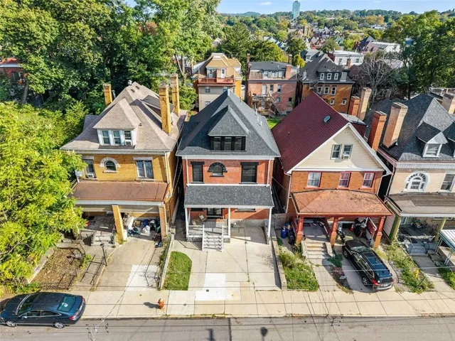 an aerial view of residential houses with yard and mountain view in back