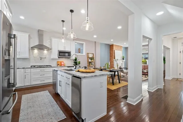 a kitchen with stainless steel appliances granite countertop a sink stove and refrigerator