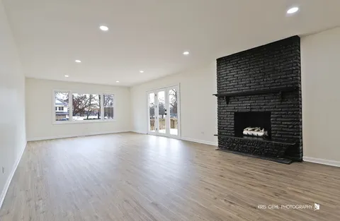 a view of an empty room with a fireplace and a window