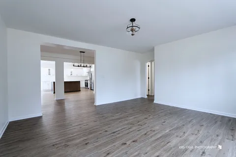 a view of empty room with wooden floor and fireplace