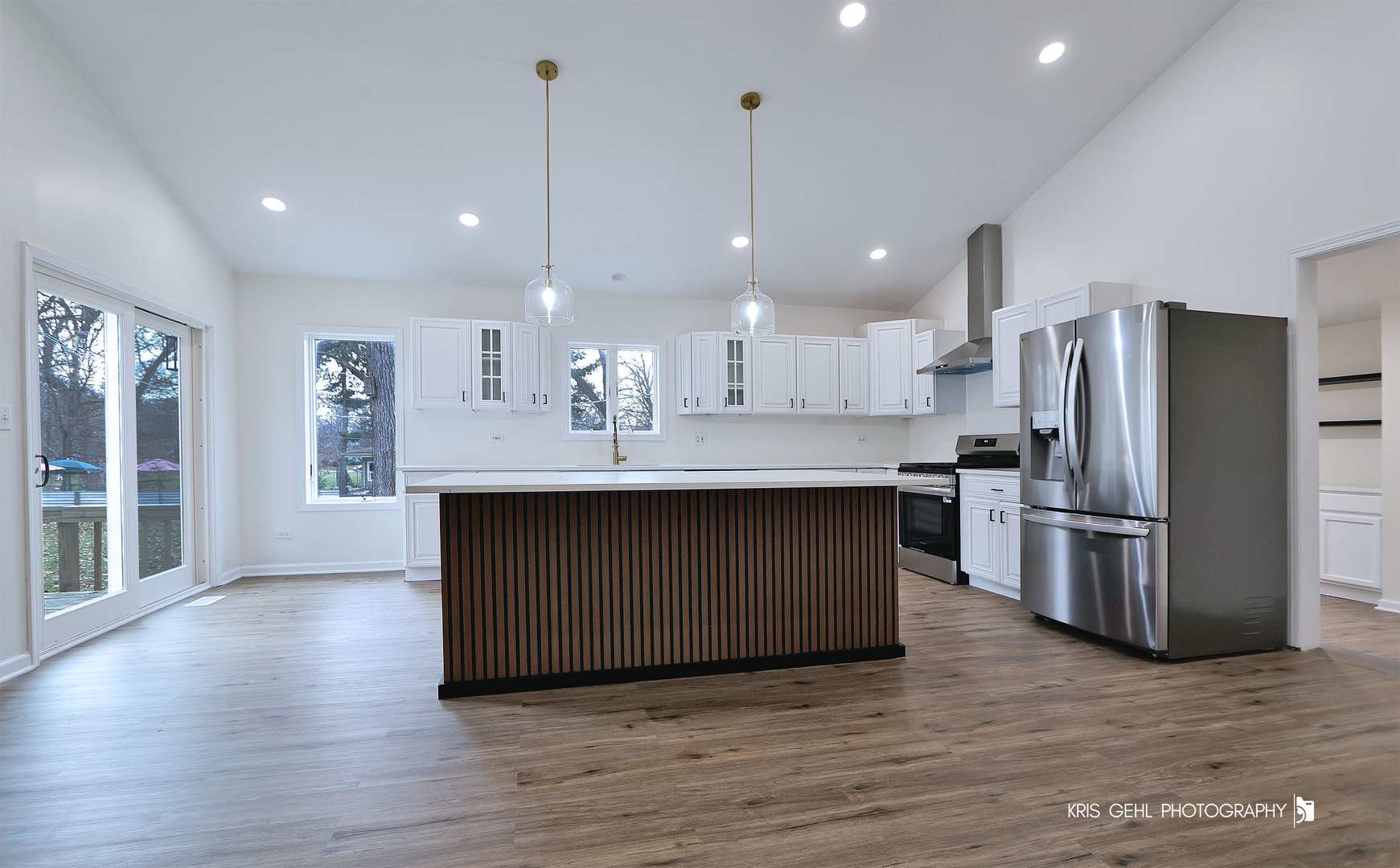 18653 West Willow Point Road Grayslake, IL 60030 - Photo 10 of 49 a kitchen with kitchen island white cabinets stainless steel appliances and wooden floor