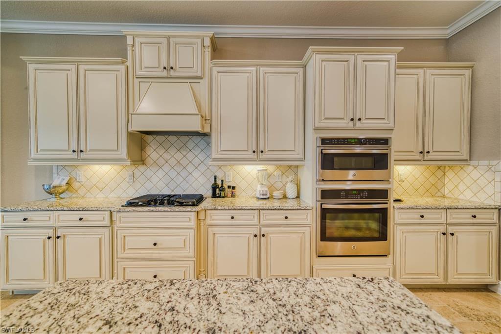 9902 Corso Bello Drive Naples, FL 34113 - Photo 15 of 45 a kitchen with granite countertop a sink cabinets and stainless steel appliances