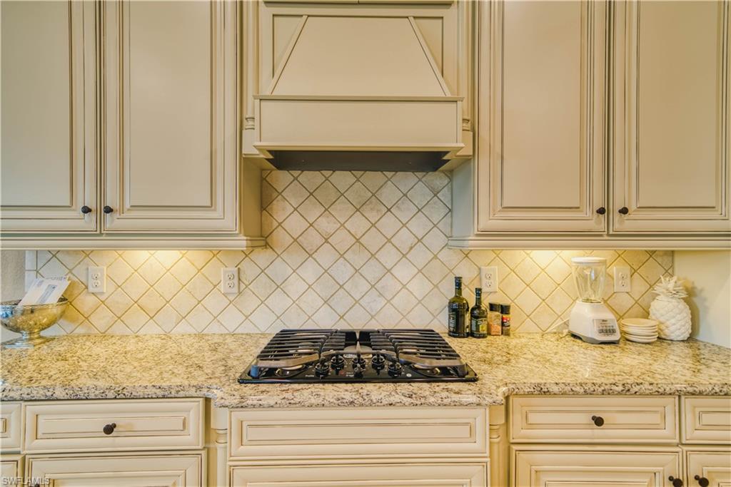 9902 Corso Bello Drive Naples, FL 34113 - Photo 16 of 45 a kitchen with granite countertop white cabinets and a white stove