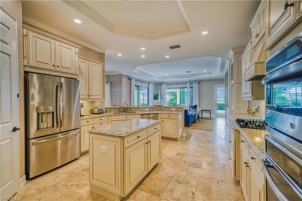 9902 Corso Bello Drive Naples, FL 34113 - Photo 20 of 45 a kitchen with stainless steel appliances granite countertop a refrigerator and a stove top oven