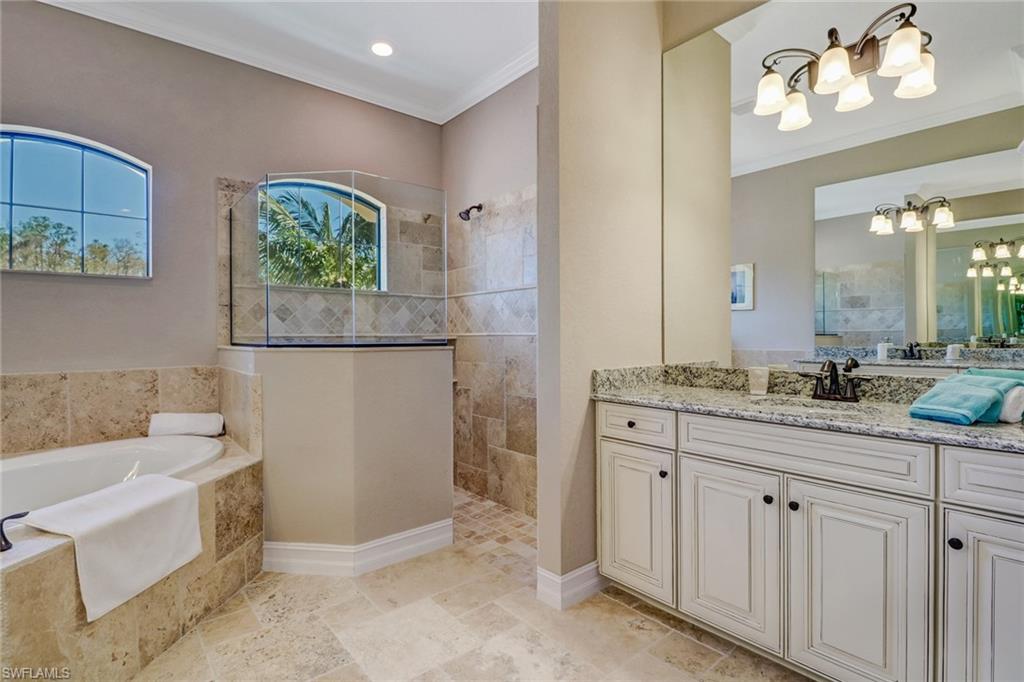 9902 Corso Bello Drive Naples, FL 34113 - Photo 25 of 45 a spacious bathroom with a granite countertop sink a toilet a mirror and vanity