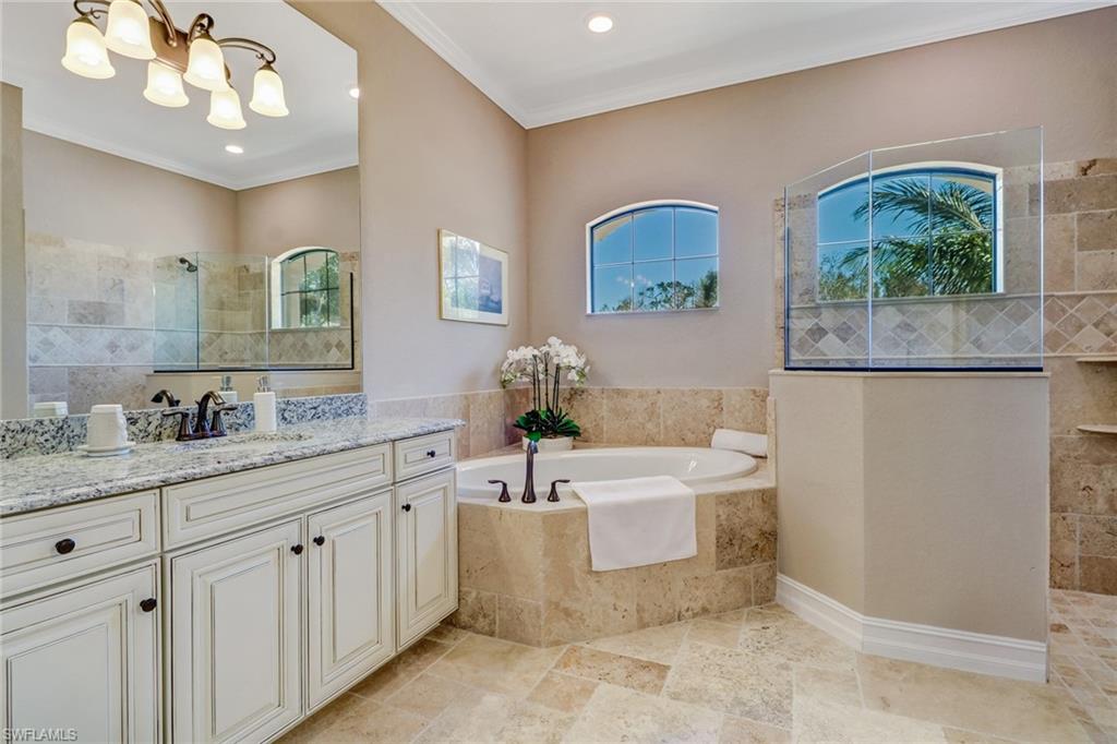 9902 Corso Bello Drive Naples, FL 34113 - Photo 26 of 45 a bathroom with a double vanity sink a mirror and a bathtub
