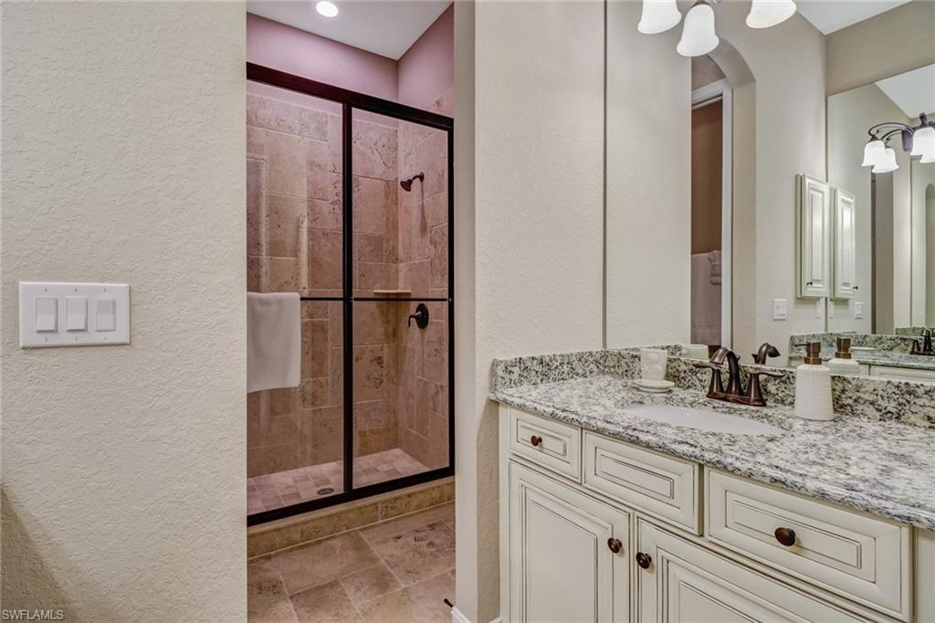 9902 Corso Bello Drive Naples, FL 34113 - Photo 32 of 45 a bathroom with a granite countertop sink and a mirror
