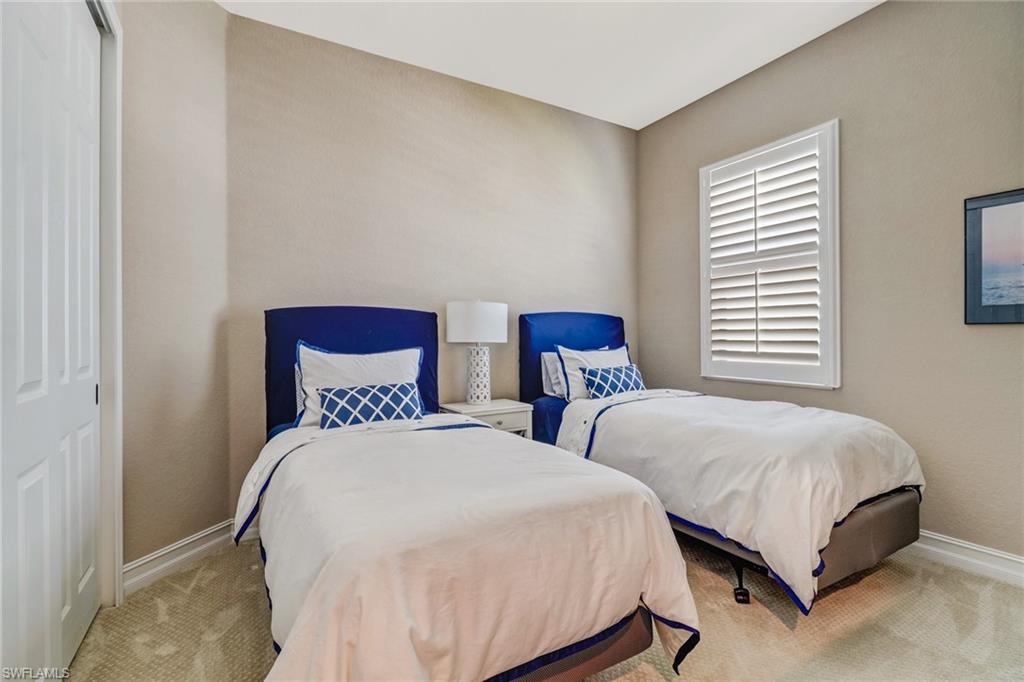 9902 Corso Bello Drive Naples, FL 34113 - Photo 33 of 45 a bedroom with two beds and a night stand