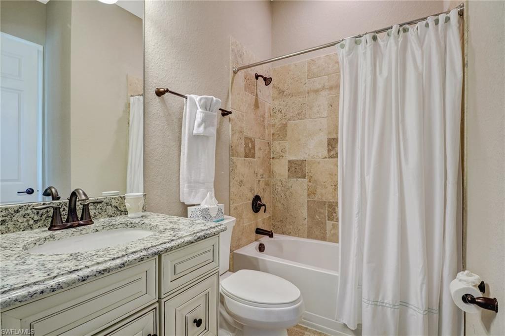 9902 Corso Bello Drive Naples, FL 34113 - Photo 34 of 45 a bathroom with a granite countertop sink toilet and shower