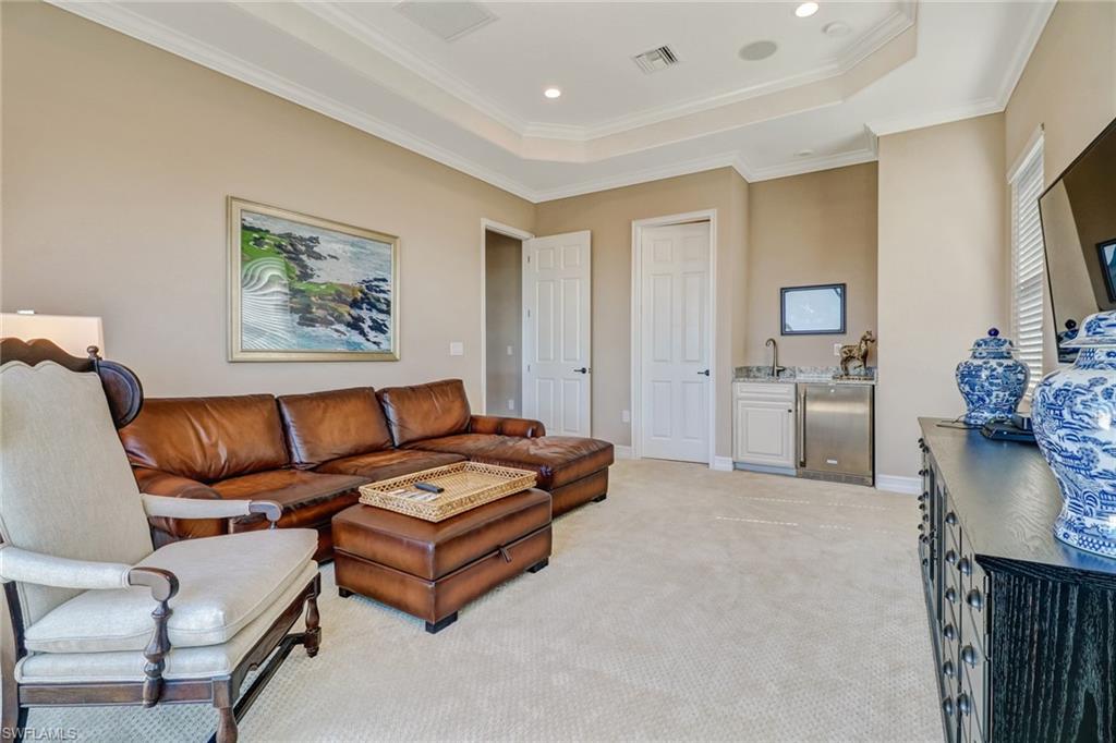9902 Corso Bello Drive Naples, FL 34113 - Photo 36 of 45 a spacious bedroom with a bed a couch and a view of kitchen