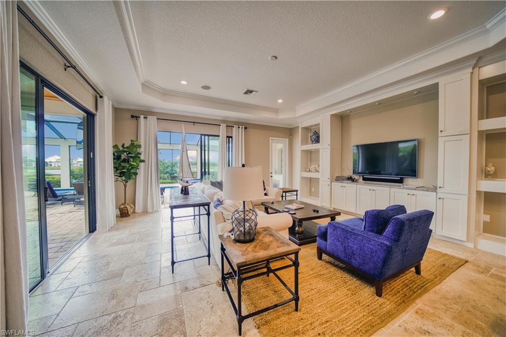 9902 Corso Bello Drive Naples, FL 34113 - Photo 9 of 45 a living room with furniture and a flat screen tv