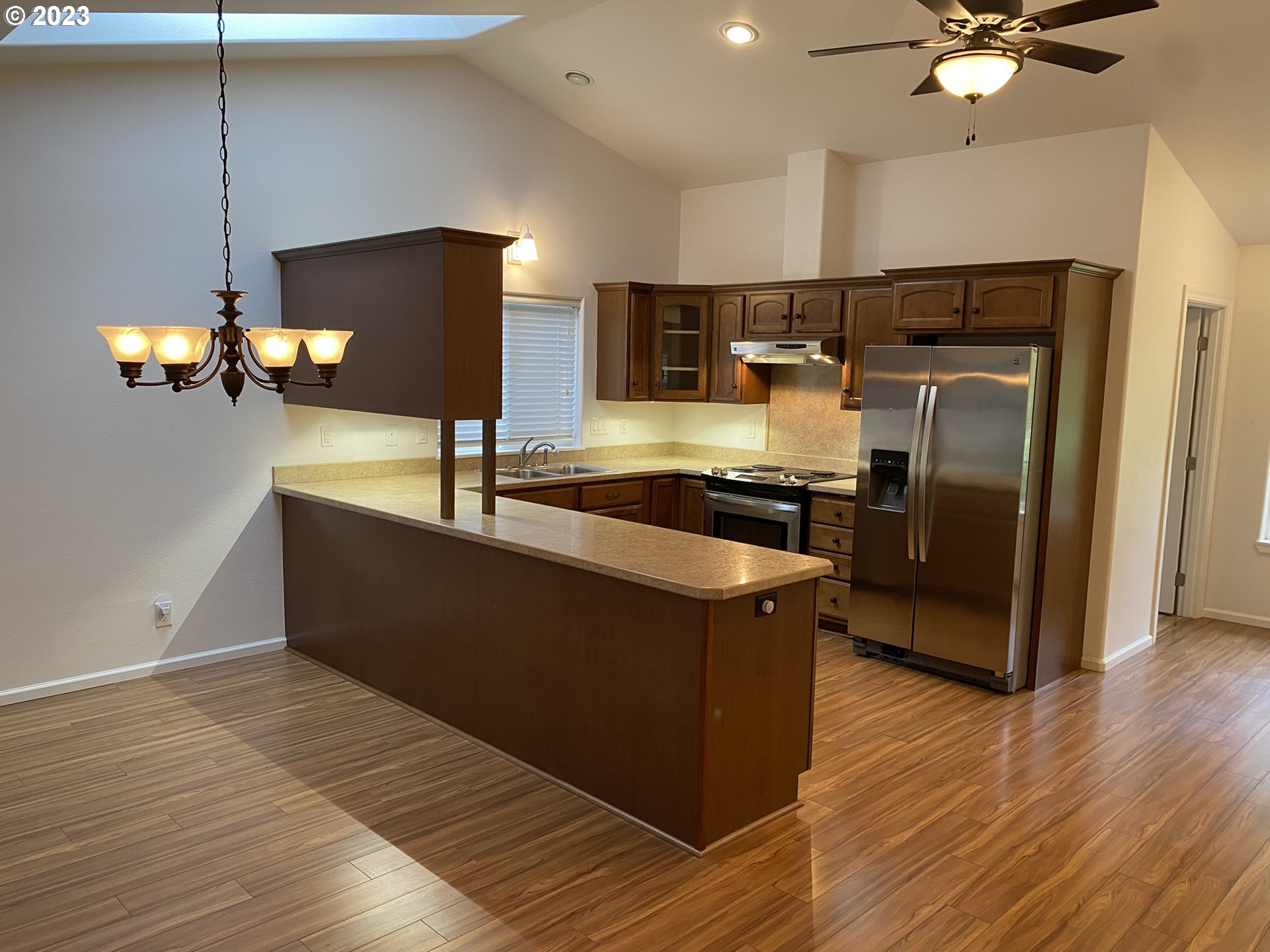 4863 Darlings Loop Florence, OR 97439 - Photo 12 of 47 a kitchen with kitchen island stainless steel appliances a sink and a refrigerator