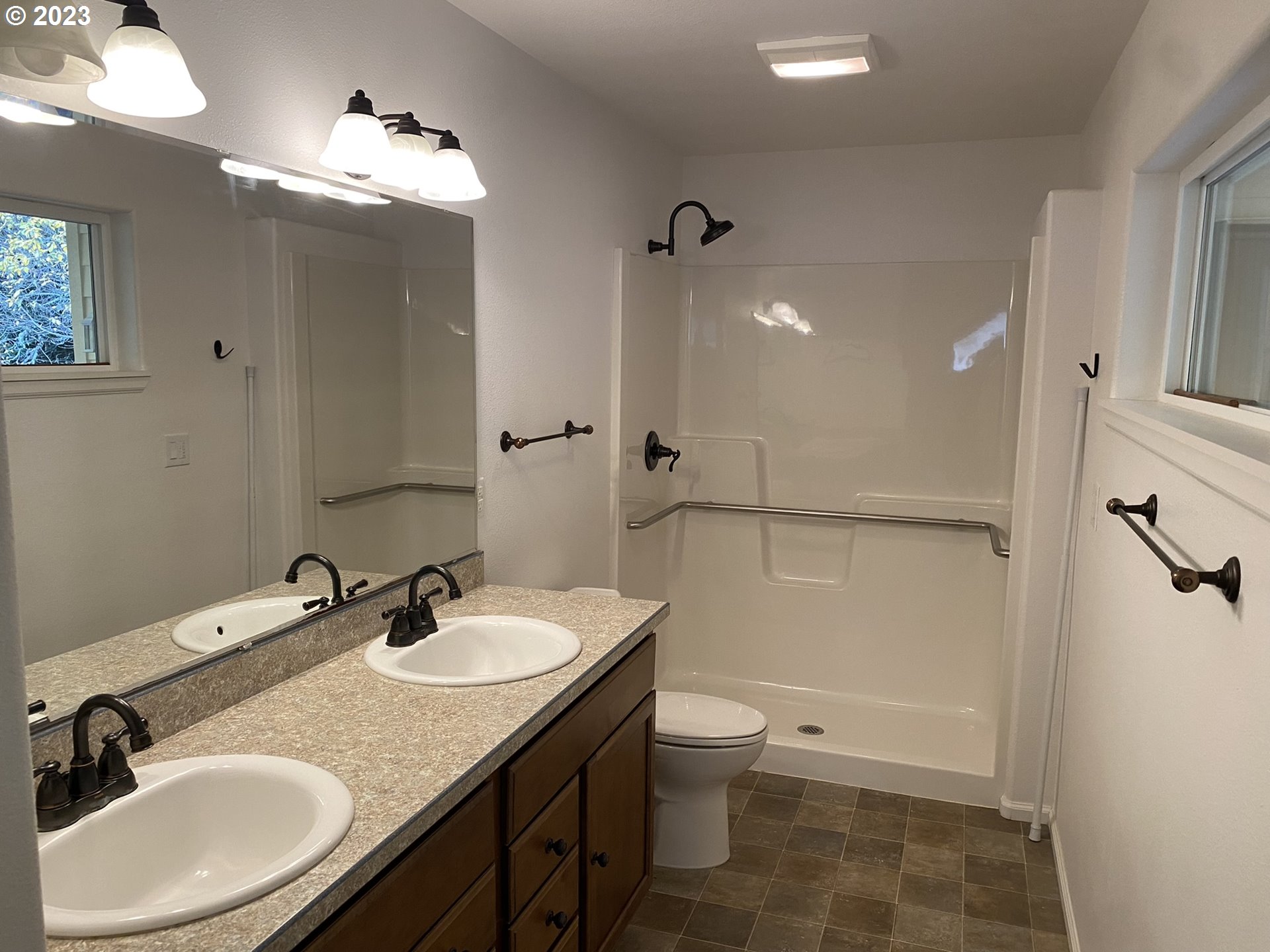 4863 Darlings Loop Florence, OR 97439 - Photo 26 of 47 a bathroom with a granite countertop sink toilet a mirror and shower
