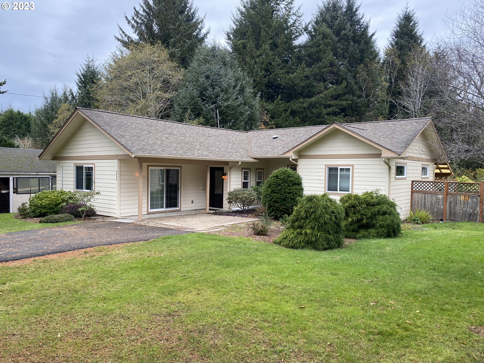 4863 Darlings Loop Florence, OR 97439 - Photo 3 of 47 a front view of a house with a yard and garage