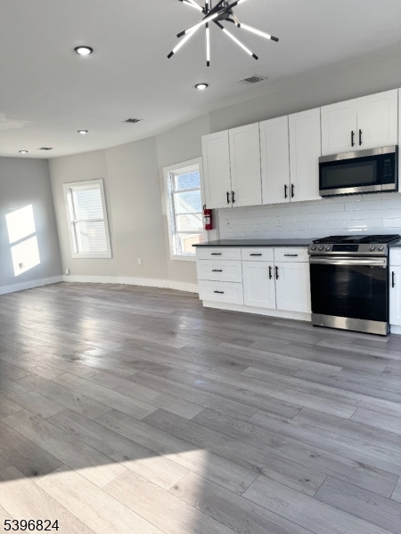 626 South 20th Street, Unit 3 Newark, NJ 07103 - Photo 3 of 12 a kitchen with stainless steel appliances kitchen island granite countertop a stove a sink and white cabinets