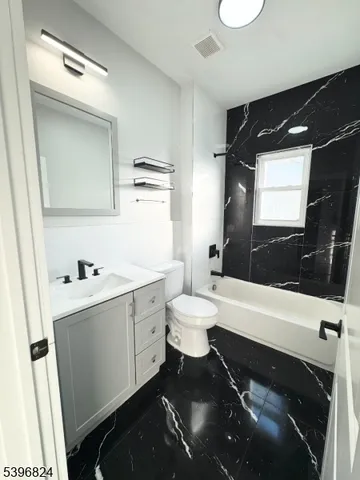 a bathroom with a sink a toilet a mirror and a bathtub