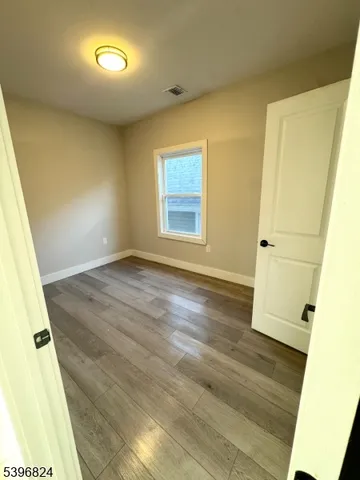 an empty room with wooden floor and white walls