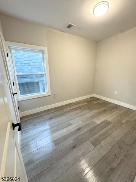 626 South 20th Street, Unit 3 Newark, NJ 07103 - Photo 7 of 12 an empty room with wooden floor and window