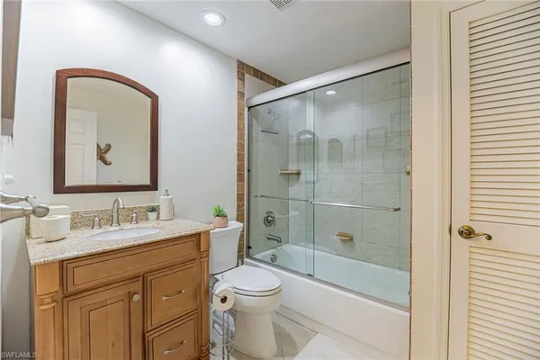 a bathroom with a double vanity sink toilet mirror and shower