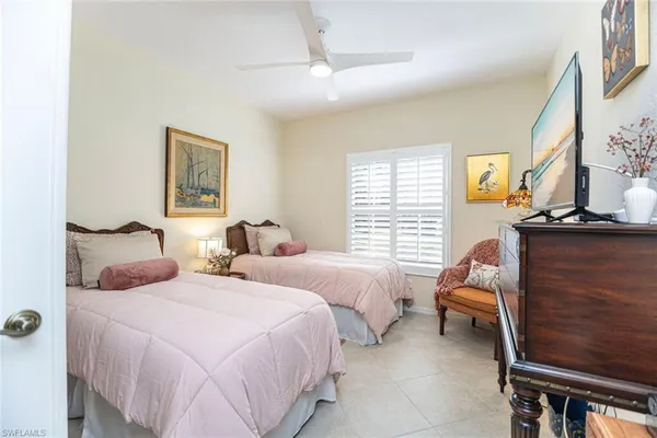 a bedroom with two beds and painting on the wall