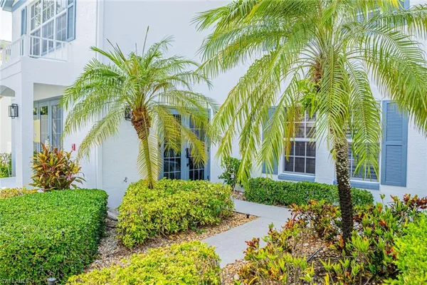 front view of a house with a yard and potted plants