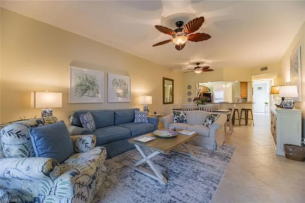 a living room with lots of furniture and view of kitchen
