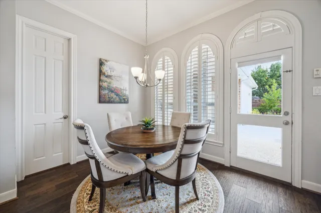 a dining room with furniture a chandelier and wooden floor