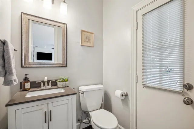 a bathroom with a toilet a sink and mirror