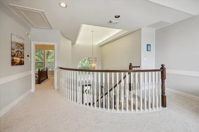 a view of staircase with lots of frames on wall and a large window