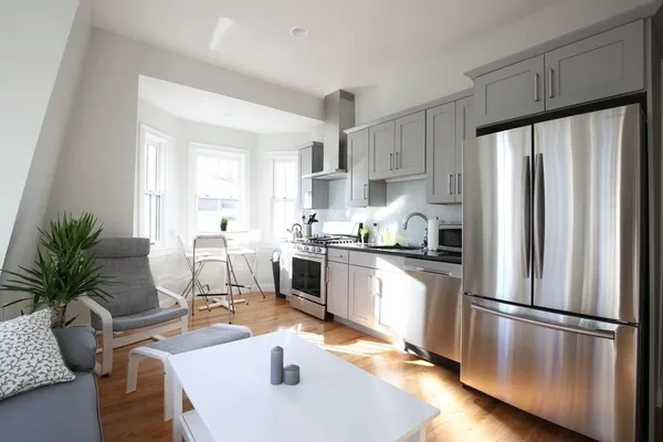 a kitchen with stainless steel appliances a refrigerator a sink a stove a table and chairs