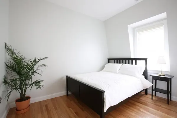 a bedroom with a bed and a potted plant