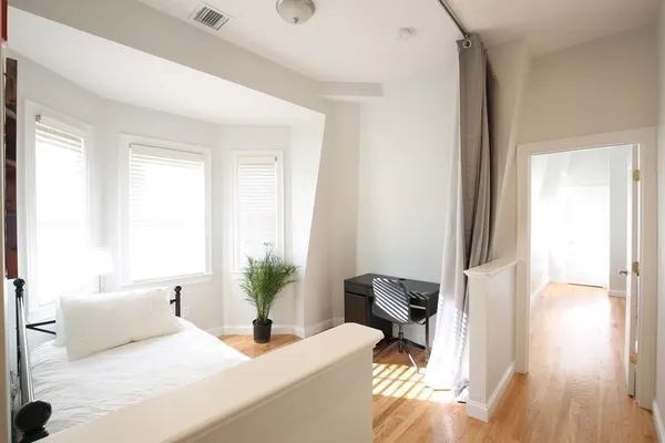 a bedroom with a bed and a potted plant