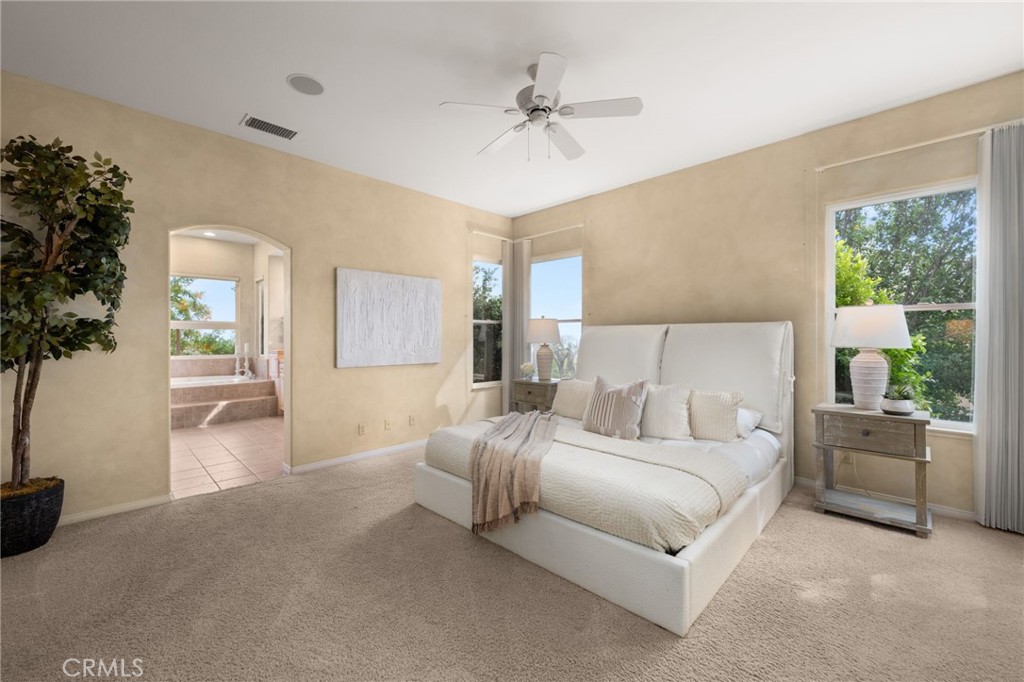 5501 Carriage Place Rancho Cucamonga, CA 91737 - Photo 23 of 60 a spacious bedroom with a bed a couch and a potted plant