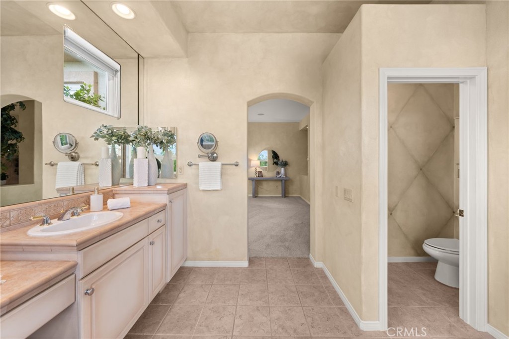 5501 Carriage Place Rancho Cucamonga, CA 91737 - Photo 29 of 60 a en suite bathroom with a sink a toilet and a mirror