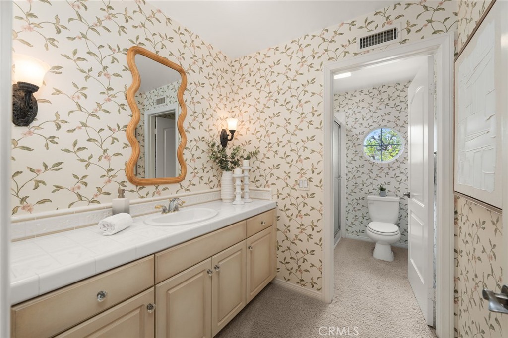 5501 Carriage Place Rancho Cucamonga, CA 91737 - Photo 33 of 60 a bathroom with a granite countertop toilet a sink and a mirror
