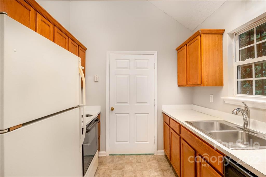 2800 Oneida Road Charlotte, NC 28269 - Photo 4 of 18 a kitchen with a sink a refrigerator and a window