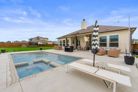 a kitchen with stainless steel appliances a dining table chairs refrigerator and microwave