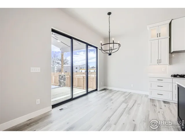 an empty room with wooden floor a ceiling fan and windows