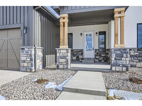 a large kitchen with stainless steel appliances kitchen island granite countertop a refrigerator a sink a stove and white cabinets with wooden floor