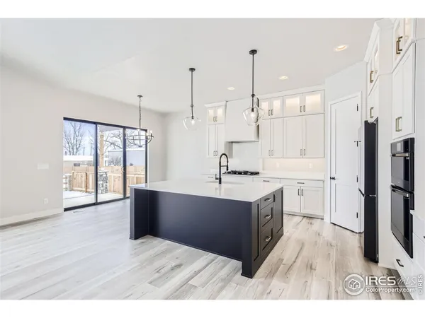 a kitchen with a sink cabinets and wooden floor